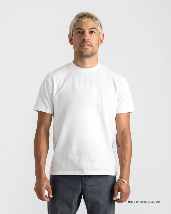 Man wearing a plain white t-shirt against a white background