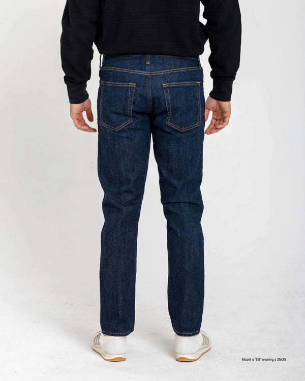 Person wearing blue jeans from behind on a white background