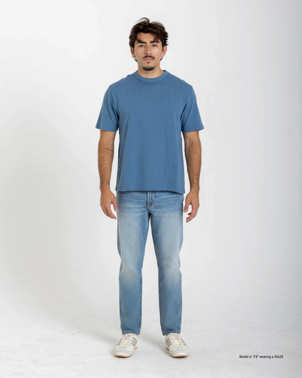 Short Man wearing a blue t-shirt and jeans on a white background