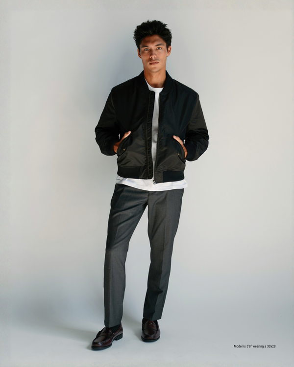 5'8" man wearing charcoal straight menswear trousers in a 30x28 with a black bomber jacket and penny loafers
