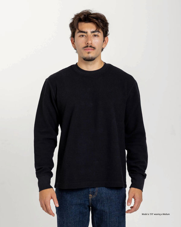 Man wearing a black long-sleeve shirt against a white background